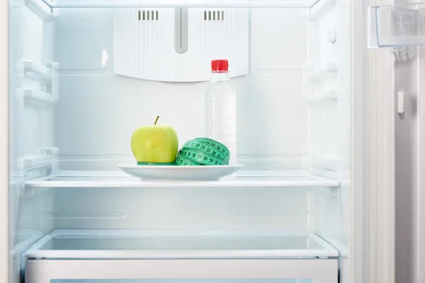 Apple with measuring tape on plate with bottle of water — Stock Photo, Image