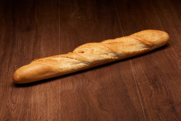 Pane baguette francese su tavolo di legno scuro — Foto Stock