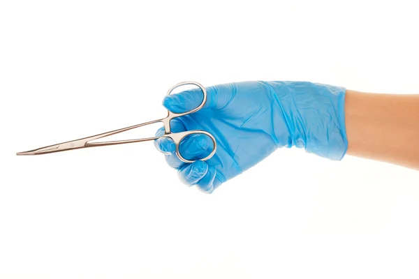 Närbild på kvinnliga läkarens hand i blå steriliserad kirurgiska handske med pincett mot vit — Stockfoto
