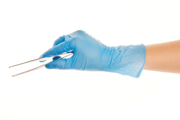 Close up of female doctor's hand in blue sterilized surgical glove with forceps against white — Stock Photo, Image