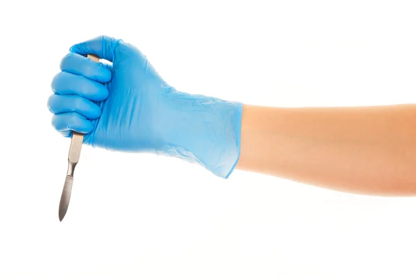 Close up of female doctor's hand in blue sterilized surgical glove with scalpel against white — Stock Photo, Image