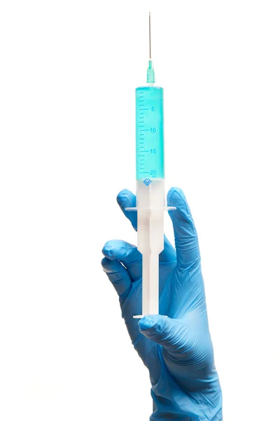 Close up of female doctor's hand in blue sterilized surgical glove with plastic medical syringe — Stock Photo, Image