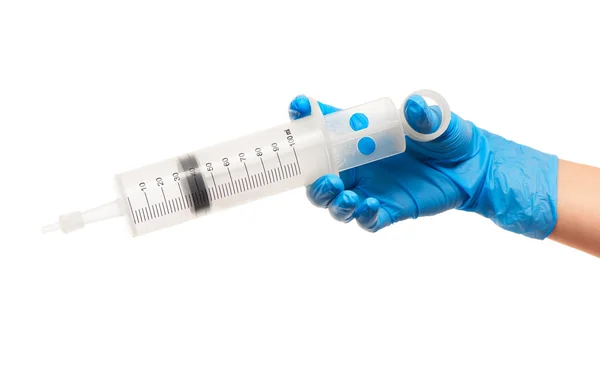 Закрыть руку женщины-врача в синей хирургической перчатке с большим пластиковым медицинским шприцем для чистки ушей — стоковое фото