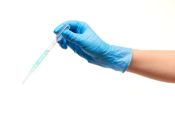 Primer plano de la mano del médico femenino en guante quirúrgico esterilizado azul con gotero médico plástico lleno de droga azul —  Fotos de Stock