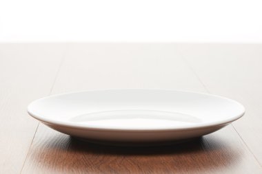 Parlak kahverengi ahşap masa lambası arka plan üzerinde beyaz seramik tabak