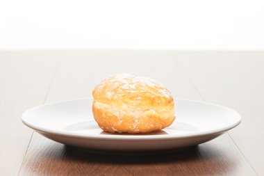 Krema şeker beyaz seramik plaka üzerinde parlak kahverengi ahşap masa lambası ile halka