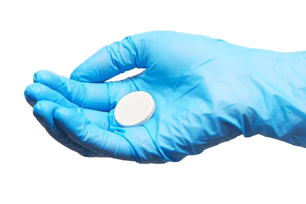 Stora runda vita tablet på kvinnliga läkarens hand i blå steriliserad kirurgiska handskar — Stockfoto