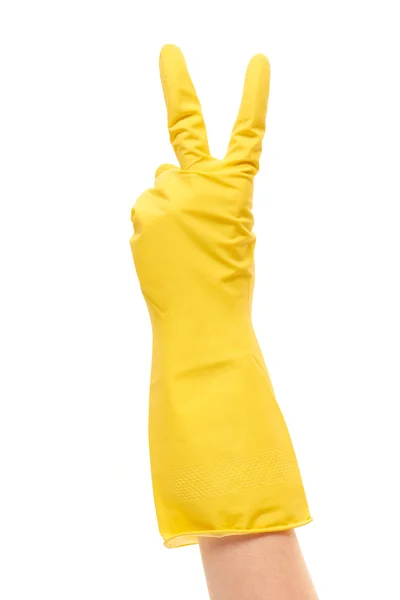 Female hand in yellow protective glove showing victory sign — Stockfoto