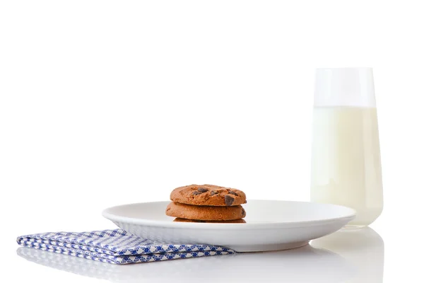 Homemade chocolate chip cookies on white ceramic plate on blue napkin and glass of milk — Stock Photo, Image