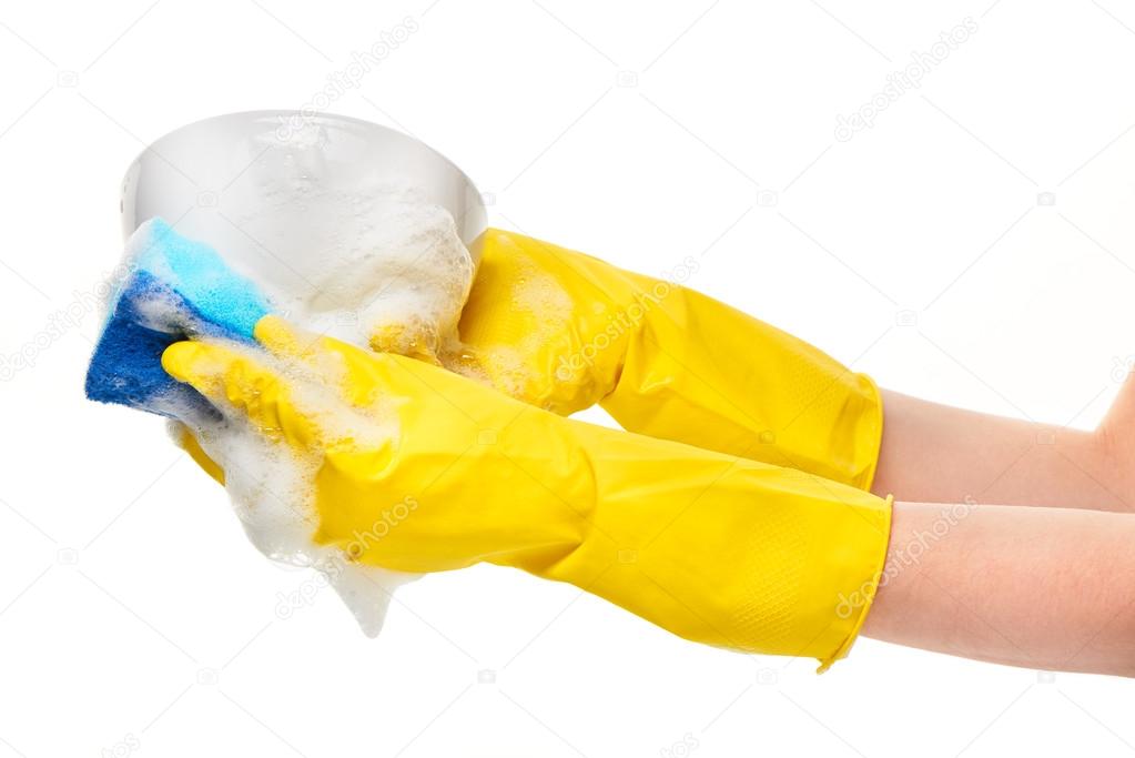 Hands in yellow protective rubber gloves washing white bowl with blue cleaning sponge