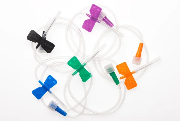 Black, orange, green, blue and purple butterfly plastic catheters with needles closed by protective caps — Stock Photo, Image