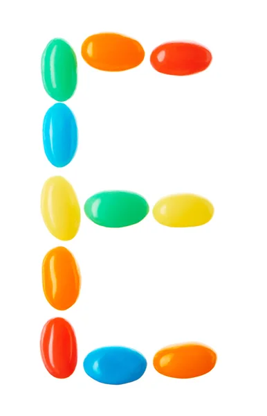 E lettera fatta di caramelle multicolori isolate su bianco — Foto Stock