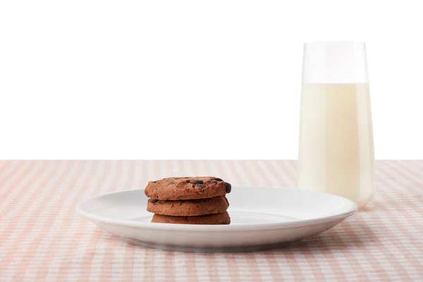 Chocolate chip cookies on plate and glass of milk — Stock Photo, Image