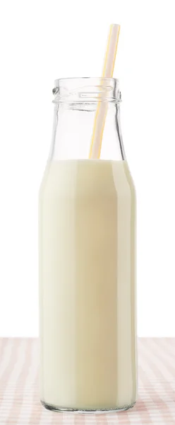 Bottle of milk with straw on checkered tablecloth — Stock Photo, Image