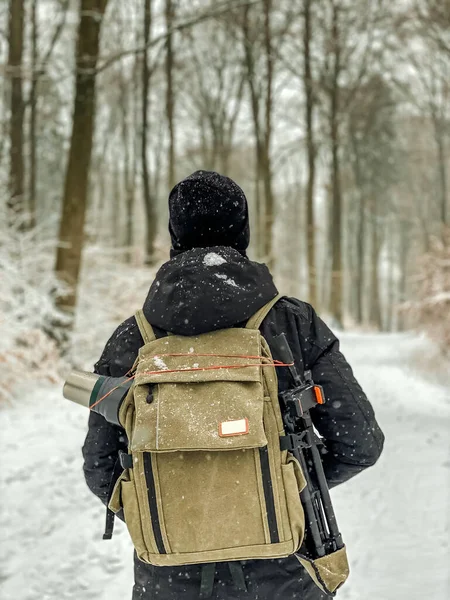 Człowiek spacerujący w lesie ze śniegiem widok z tyłu — Zdjęcie stockowe