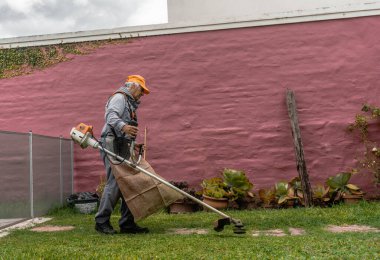 Bahçıvan bir evin arka bahçesinde çalışıyor.
