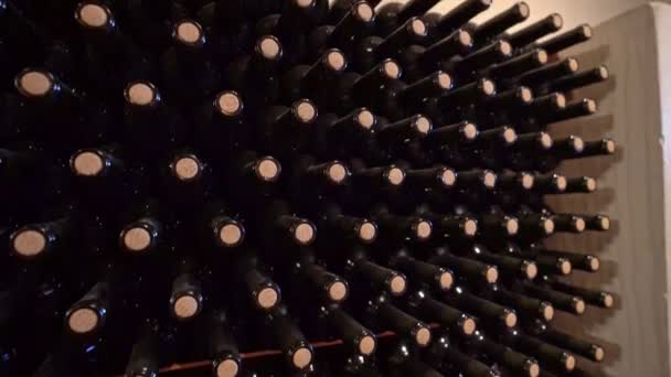 Top down shot of wine bottles stacked on a rack in a wine cellar — Stock Video