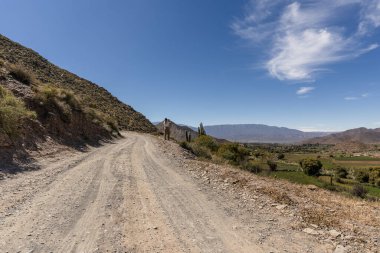 İspanyol son sınıf öğrencisi kadın yol kenarındaki dağların fotoğrafını çekiyor.