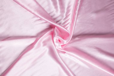 Renkli gül tekstil kumaşı kıvrımlar ve dalgalar halinde kıvrılmış, parlak ışık ve desen parıldıyor.