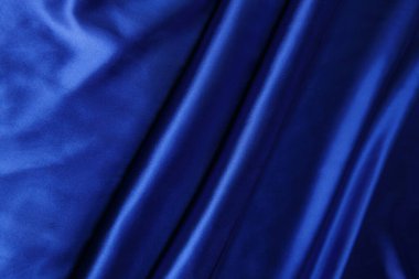 Renkli mavi tekstil kumaşı kıvrım kıvrım kıvrım ve dalgalar halinde ışık saçar.