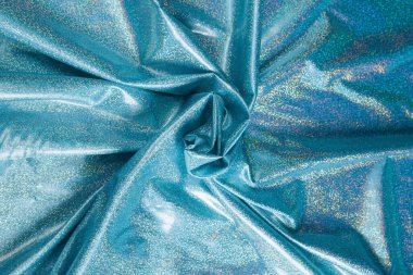 Renkli mavi tekstil kumaşı kıvrım kıvrım kıvrım ve dalgalar halinde ışık saçar.