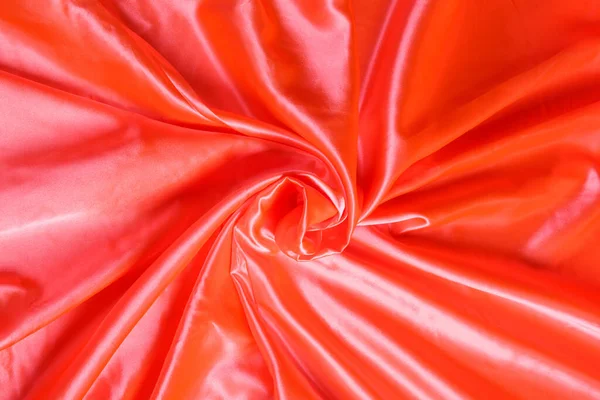 折り畳まれたオレンジ色のテキスタイルサテン生地と光のハイライトとテクスチャのシマーと波 — ストック写真