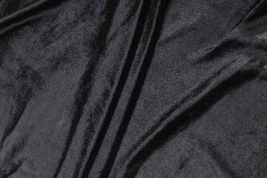 Renkli siyah tekstil kumaşı kıvrımlar ve dalgalar halinde kıvrılmış, parlak ışık ve desen parıldıyor.