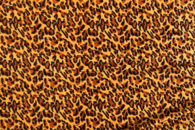 Renkli kahverengi tekstil kumaşı kıvrımlar ve dalgalar halinde kıvrılmış, parlak ışık ve desen parıldıyor.