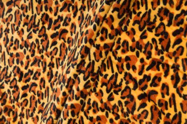 Renkli kahverengi tekstil kumaşı kıvrımlar ve dalgalar halinde kıvrılmış, parlak ışık ve desen parıldıyor.