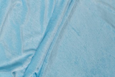 Renkli mavi tekstil kumaşı kıvrım kıvrım kıvrım ve dalgalar halinde ışık saçar.