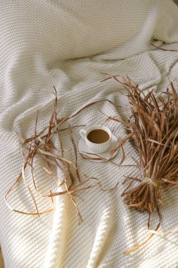 Sabahın köründe yünlü bir battaniyenin üzerinde bir fincan kahve.