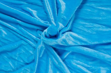 Renkli mavi tekstil kumaşı kıvrım kıvrım kıvrım ve dalgalar halinde ışık saçar.