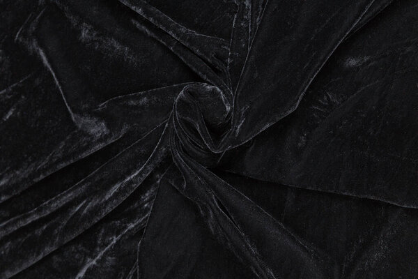 Colored black textile satin fabric folded in folds and waves with highlights and texture shimmers in the light