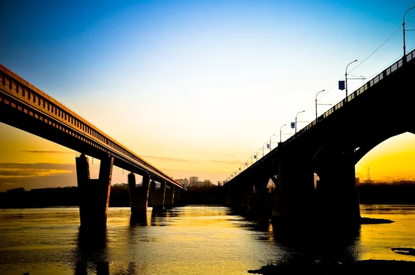 夕暮れ時に川を渡る橋 — ストック写真