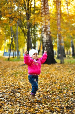 gülüyor ve sonbaharda oynayan bebek kız