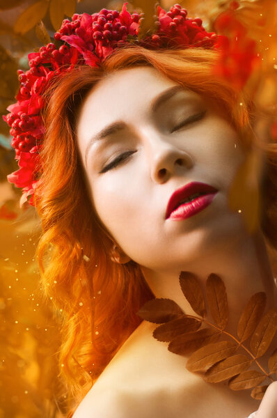 Colorful autumn portrait of beautiful red head model with rowan berries