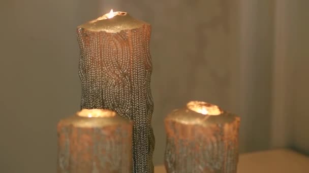 Three large gold burning candles — Stock Video