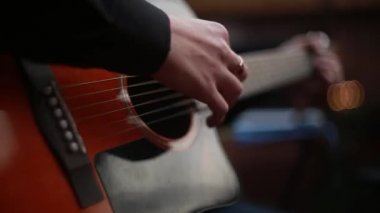 adam bir 6 telli akustik gitar çalmaya