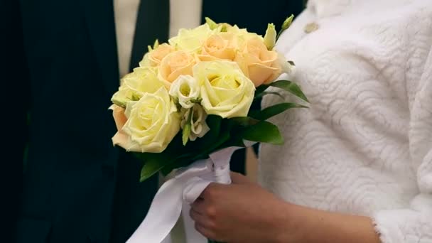 Bruiloft boeket van bloemen in handen van de bruid op groene achtergrond — Stockvideo