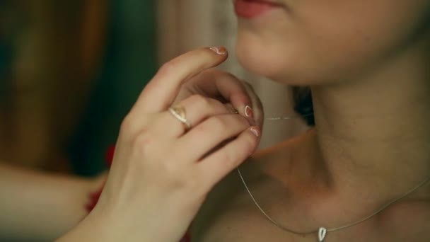 Bride preparing to wedding ceremony, her mother helps to put on jewelry — Stock Video