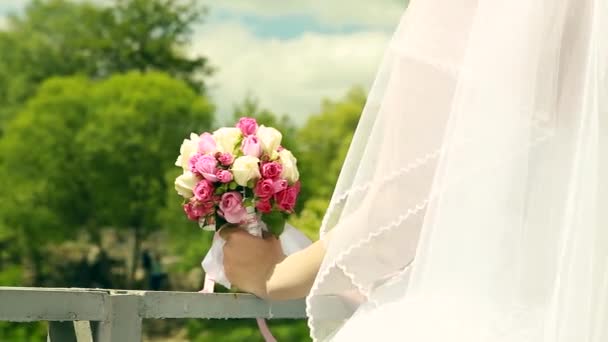 El ramo de boda de las flores en las manos de la novia sobre el fondo verde — Vídeos de Stock