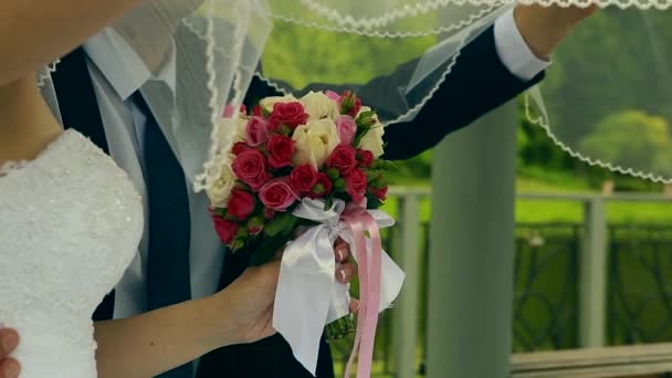 El ramo de boda de las flores en las manos de la novia sobre el fondo verde — Vídeos de Stock