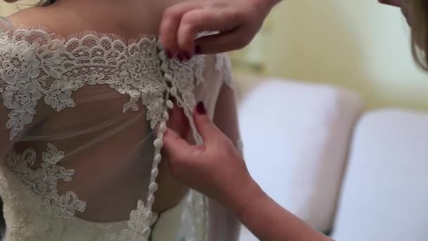 Brautjungfer macht Schleife-Knoten auf dem Rücken der Bräute Brautkleid — Stockvideo