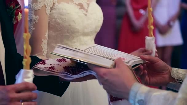 Γάμος στην εκκλησία, νύφη και γαμπρός. Γαμήλια τελετή. Νύφη και ο γαμπρός με κεριά στην εκκλησία. — Αρχείο Βίντεο