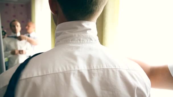 A groom putting on cuff-links as he gets dressed in formal wear — Stock Video