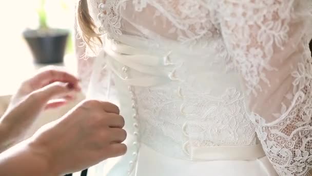 Bruidsmeisje is het helpen van de bruid te kleden — Stockvideo