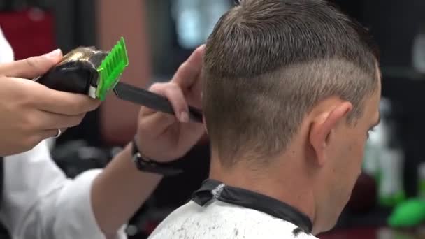 Barbeiro corta o cabelo na barbearia. Close-up — Vídeo de Stock