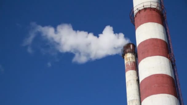 Mavi gökyüzüne karşı büyük fabrika bacaları duman — Stok video