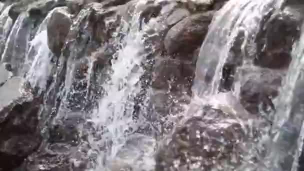 Waterval cascades stroomt over vlakke rotsen in boslandschap — Stockvideo