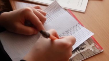 Öğrenci kalem not defterine yazdı.